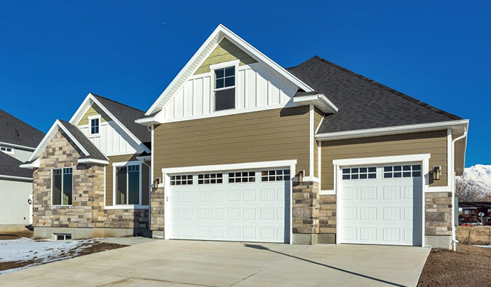 A Home Under Construction With Two Garages And A Driveway